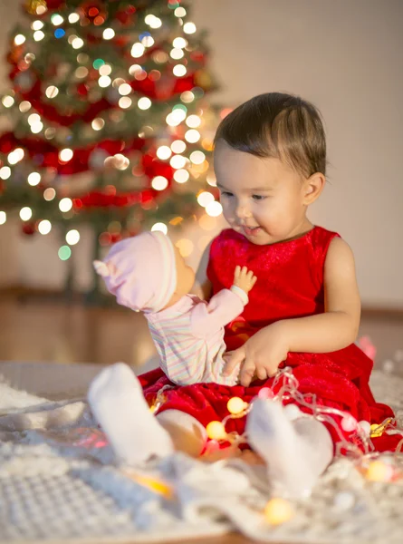 Malá dívka si hraje s její první vánoční dárek — Stock fotografie