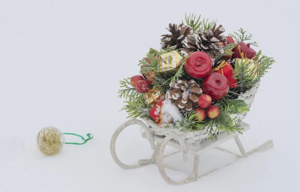 Sledge de brinquedo de madeira com decoração de Natal no fundo nevado — Fotografia de Stock