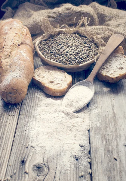 Bread, rye and a spoon with white wheat — Stock Photo, Image