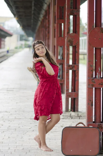 Barfota flicka med resväska väntar på stationen — Stockfoto