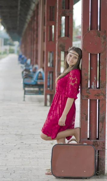Meditativ flicka med resväska väntar på stationen — Stockfoto
