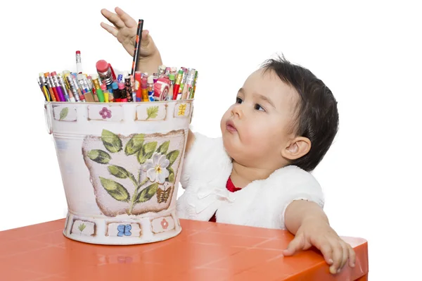 Menina com um balde de lápis à mesa — Fotografia de Stock