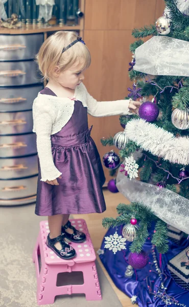 Little blonde girl decorating christmass tree — Stock Photo, Image