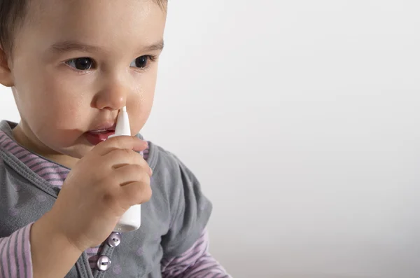 Meisje met behulp van Sandoz neusspray - witte achtergrond — Stockfoto