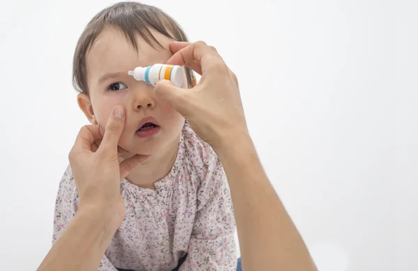 Kızı göz içinde closeup anne dökülen göz damlası — Stok fotoğraf