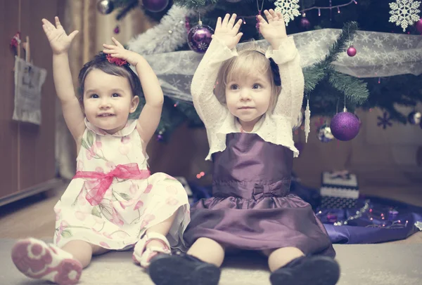 Kleine meisjes in de buurt van de kerstboom — Stockfoto