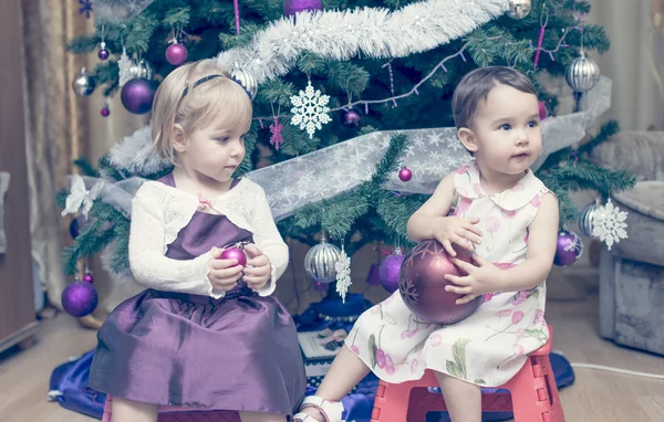 Little girls with balls near the Christmas tree — Stock Photo, Image