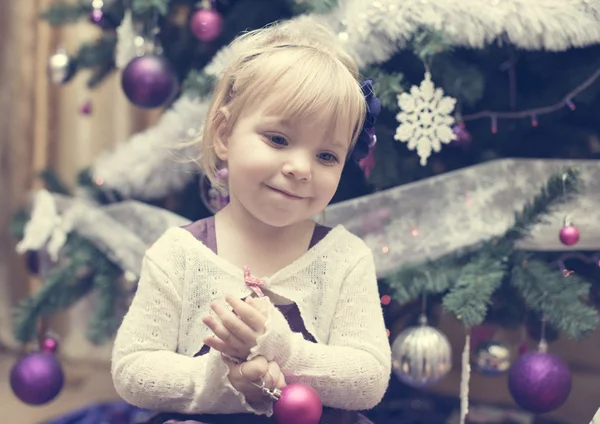 Malá blondýnka u vánočního stromu — Stock fotografie