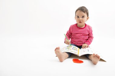 Katta oturan küçük kız çizer