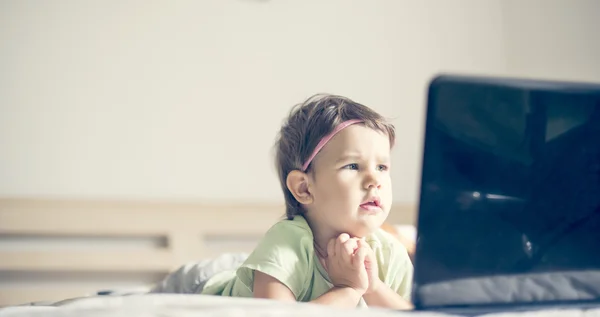 Küçük kız laptop çizgi film izlerken — Stok fotoğraf