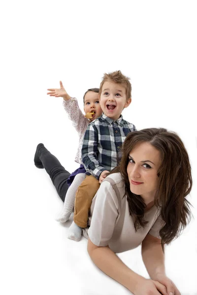 Matka daje jej córka i syn piggyback jazdy na białym tle — Zdjęcie stockowe