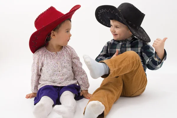 Dois irmãos sorrindo vestindo chapéus de cowboy — Fotografia de Stock