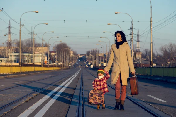 Härlig tjej och mamma med resväska på järnvägen — Stockfoto