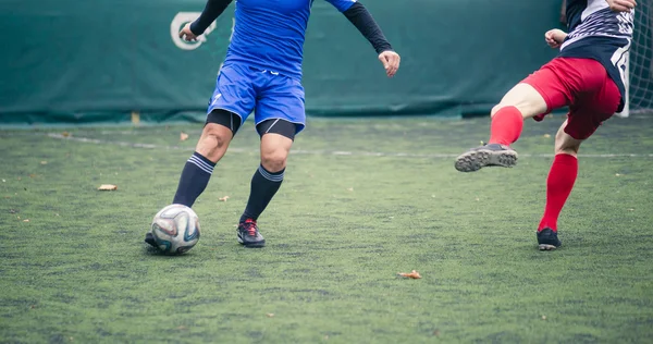 Dos futbolistas persiguiendo pelota en el campo de hierba durante el juego —  Fotos de Stock