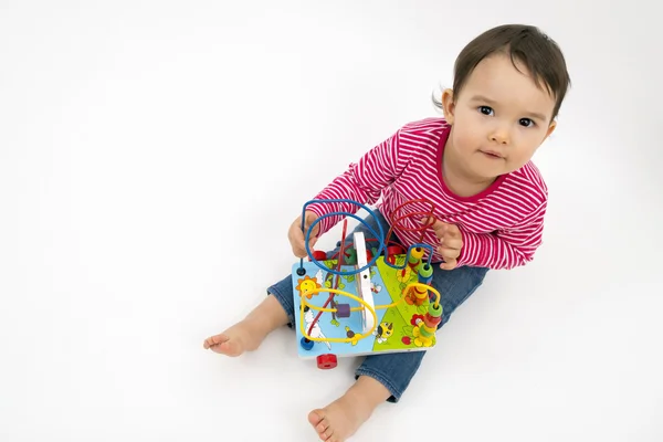 Bambina felice con colorato giocattolo di legno isolato su sfondo bianco — Foto Stock