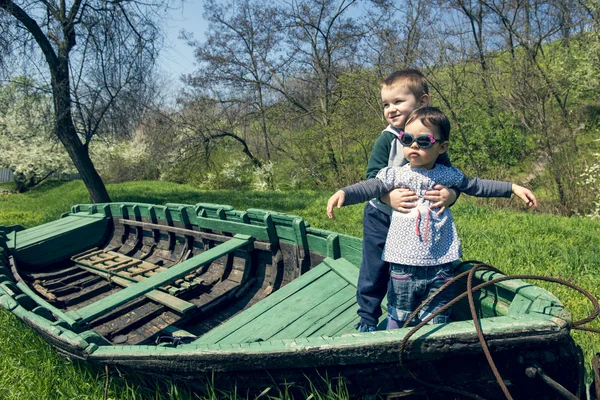 Bambina con fratello divertirsi in una vecchia barca — Foto Stock