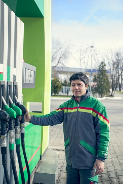 Benzin istasyonunda çalışan bir araba doldururken gülümseyen — Stok fotoğraf