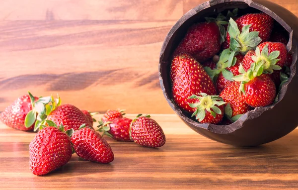 Chocolate Easter egg with the top broken off filled with strawberry — Stock Photo, Image