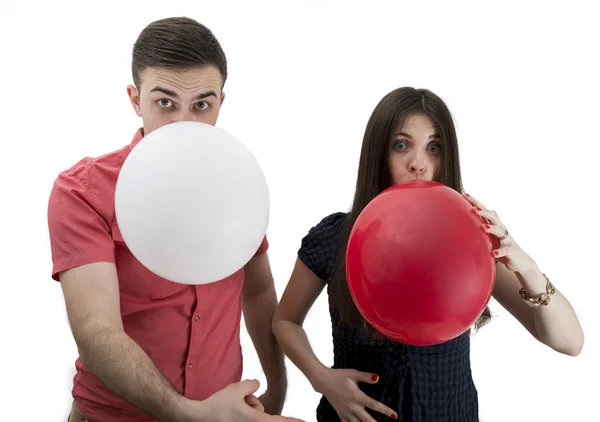 吹气球同时宣布他们的孩子的年轻夫妇 — 图库照片