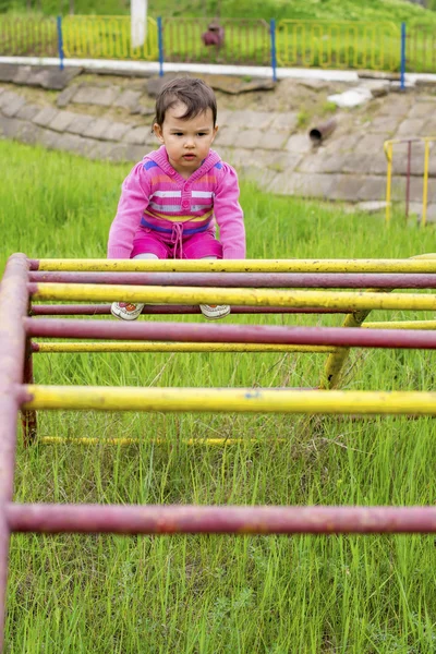 Happy little girl wspinaczka na zewnątrz plac zabaw — Zdjęcie stockowe