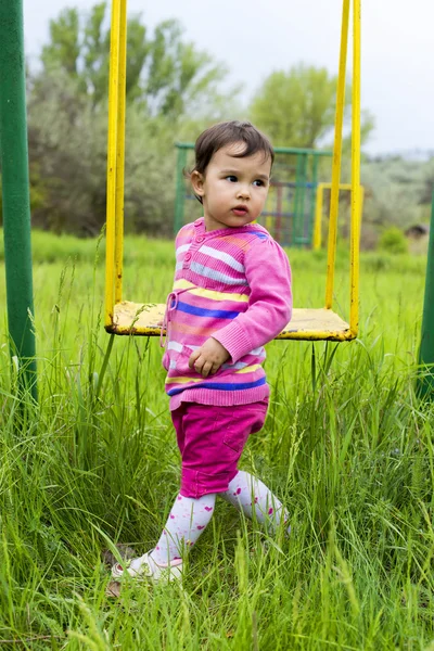Маленькая девочка на качелях — стоковое фото
