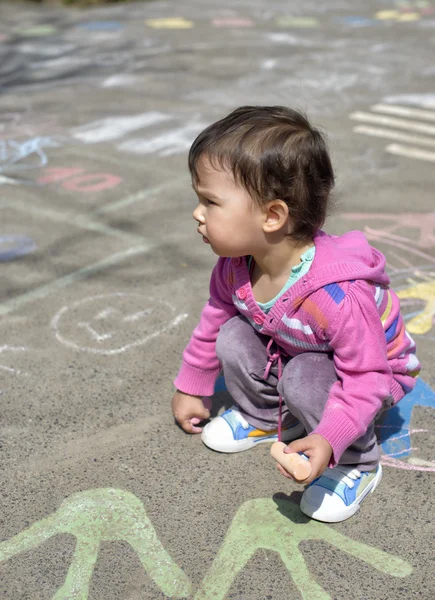 Felice bambina disegnare con gesso sul marciapiede nel parco — Foto Stock