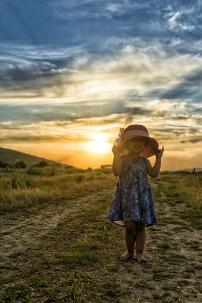 在夕阳的帽子的漂亮女孩 — 图库照片