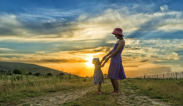 Mãe feliz e filha se divertindo ao pôr do sol — Fotografia de Stock