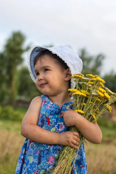 Niedliches kleines Mädchen mit einem Eimer voller Schafgarbenblüten — Stockfoto