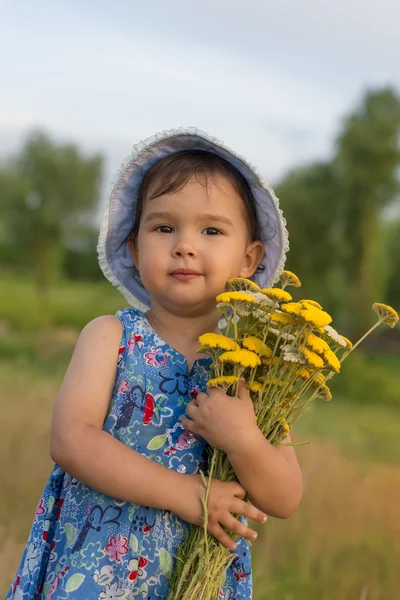 Söt liten flicka som håller en hink med yarrow blommor — Stockfoto