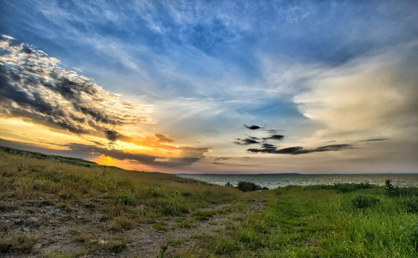 Hermoso atardecer sobre el lago con cielo nublado — Foto de Stock