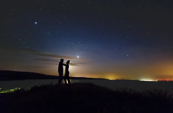 Romantický pár na západ slunce za hory — Stock fotografie