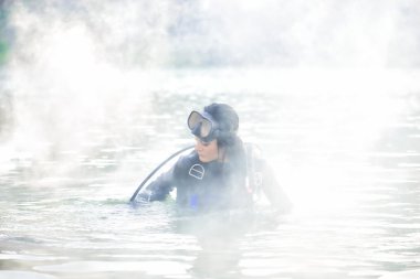 Kadın dalgıç su duman içinde kefen