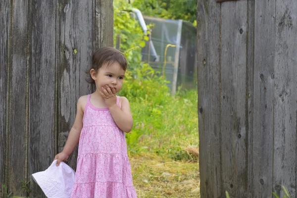 Little girl in front of the gate thinking — Stock Photo, Image