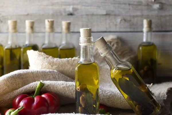 Olives et huile d'olive en mini bouteille sur table en bois — Photo