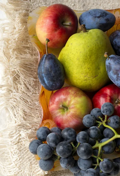 Korb voller Früchte. Birne, Apfel, Traube und Pflaume — Stockfoto