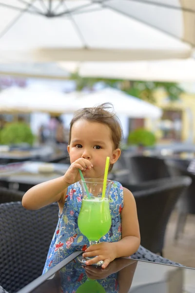 Niña está bebiendo limonada con menta usando paja — Foto de Stock