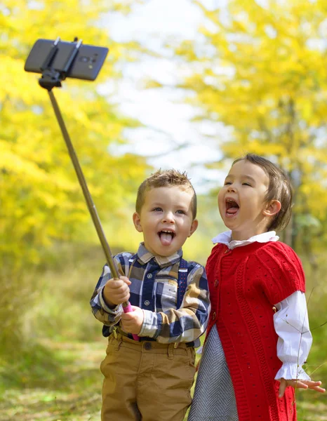 Dos niños pequeños tomando selfie en el parque —  Fotos de Stock