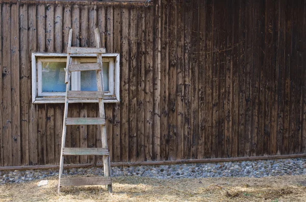 Oude ladder leunend tegen een houten huis — Stockfoto