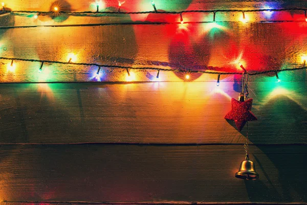 Luzes de Natal e globos sobre fundo de madeira — Fotografia de Stock