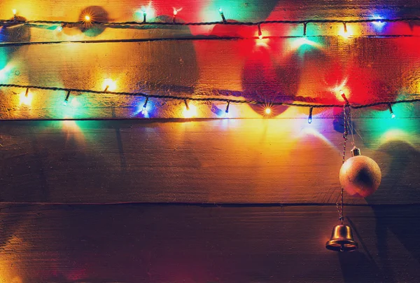 Lumières de Noël et globes sur fond bois — Photo