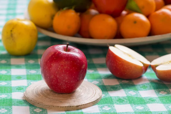 Manzana de gala fresca sobre una mesa con cesta de fruta en el fondo — Foto de Stock