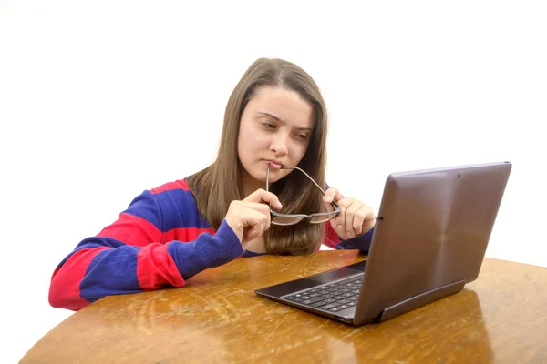 Ung flicka på skrivbordet tittar på laptop — Stockfoto