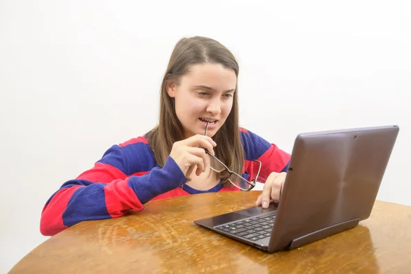 Ung flicka på skrivbordet tittar på laptop — Stockfoto