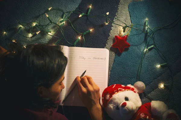 Joven mujer durmiendo en su diario en Navidad —  Fotos de Stock