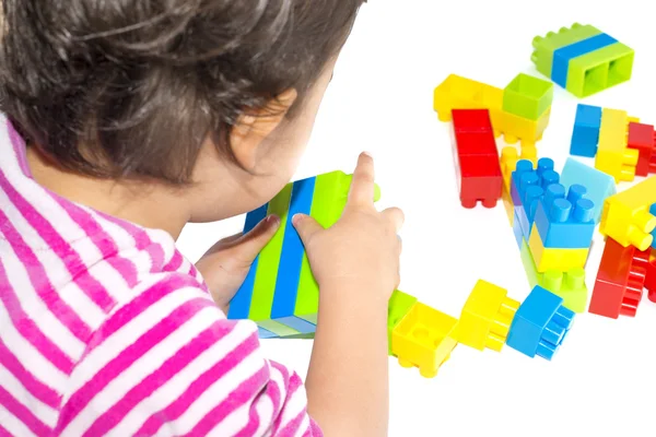 Bébé fille jouer avec des blocs colorés sur fond blanc — Photo