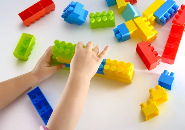 Bebé niña jugando con bloques de colores sobre fondo blanco —  Fotos de Stock