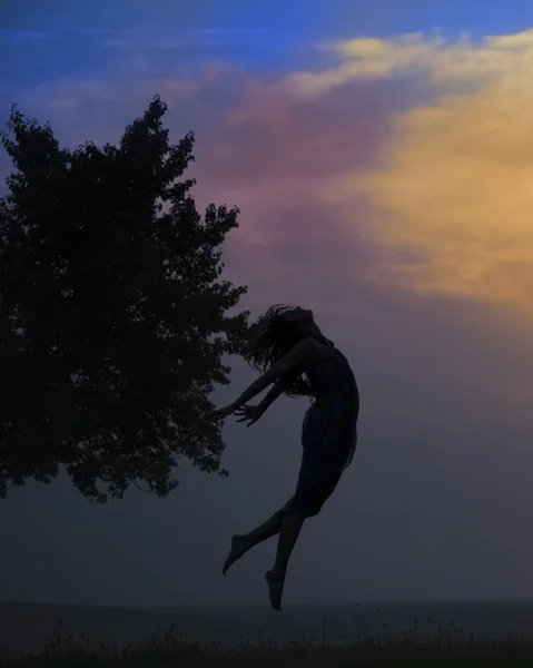 Silhouette di una bella ragazza che salta al tramonto — Foto Stock