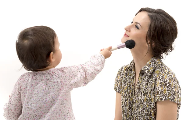 Little girl putting on the makeup to her mother — Stock Photo, Image
