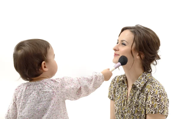 Little girl putting on the makeup to her mother — Stock Photo, Image